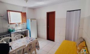 a small kitchen with a table and a refrigerator at Kactus Flat in Itacaré