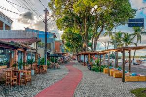 a cobblestone street with tables and chairs and a red path at Kactus Flat in Itacaré