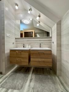 Un baño con dos lavabos y un espejo grande. en Tatra Family Loft, en Vysoké Tatry