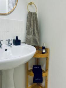 a bathroom with a white sink and a mirror at Secret Eden in Jeffreys Bay