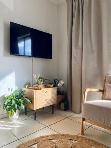 a living room with a tv on the wall at Secret Eden in Jeffreys Bay