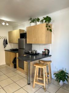 a kitchen with a black counter and wooden cabinets at Secret Eden in Jeffreys Bay