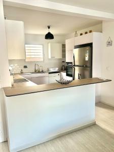 オリエントベイにあるVilla Cataleya - Jacuzzi, Pool & Sea View in Orient Bayのキッチン(白いキャビネット、大きなカウンタートップ付)