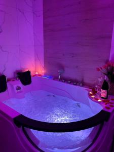 乌斯特龙Apartament z wanną z hydromasażem的客房内的紫色照明浴缸