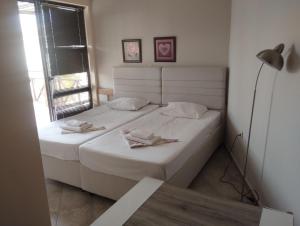 a bedroom with two beds with white sheets and a lamp at Paradise in Burgas City +5 photos