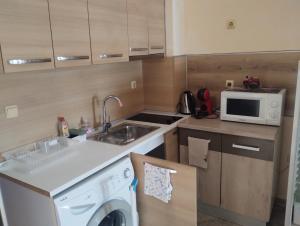 a kitchen with a washing machine and a microwave at Paradise in Burgas City