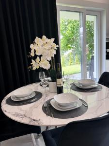 乌斯特龙Apartament z wanną z hydromasażem的餐桌,带盘子和花瓶