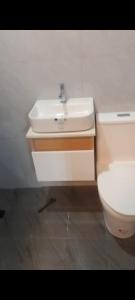 a bathroom with a white sink and a toilet at Auntie's in Tanza