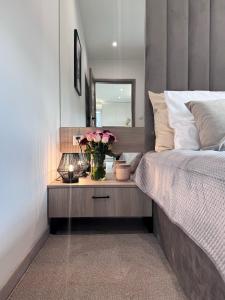 乌斯特龙Apartament z wanną z hydromasażem的卧室配有一张桌子,上面有花瓶