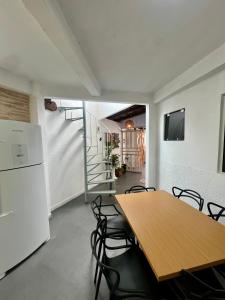 una sala da pranzo con tavolo e sedie in legno di Refúgio perto do Mar: Ótima casa a 350m da praia a Pontal do Paraná