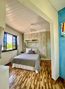 una camera da letto con un letto e una grande finestra di Refúgio perto do Mar: Ótima casa a 350m da praia a Pontal do Paraná