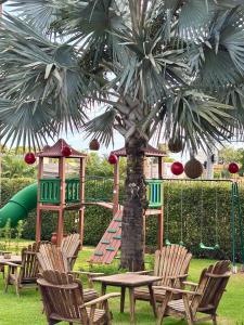 Un parque infantil con mesa y sillas y una palmera. en Hotel Roda D'Agua, en Andradina