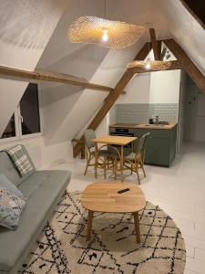 a living room with a couch and a table at Le426 Charmant T2 bis avec petite cour in Mouvaux