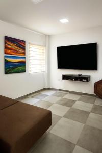 un soggiorno con una TV a schermo piatto su una parete di Black Friday en Casa de Campo Campestre ZEN a La Granja