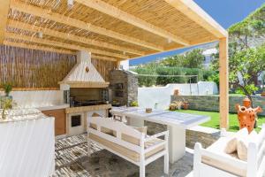 an outdoor kitchen with a table and a stove at Crystal Dream Paros in Ekatondapilianí