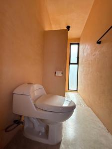 a white toilet in a bathroom with a window at Casa Melon 1BR Spectacular Private Oceanview Terrace in Santa María Colotepec +11 photos