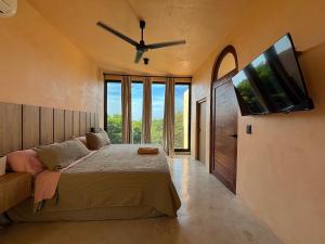 a bedroom with a large bed with a ceiling fan at Casa Melon 1BR Spectacular Private Oceanview Terrace in Santa María Colotepec