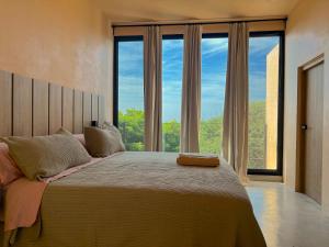 a bedroom with a large bed with a large window at Casa Melon 1BR Spectacular Private Oceanview Terrace in Santa María Colotepec