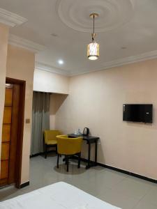 a room with a table and a yellow chair at HÔTEL Michou in Bafoussam