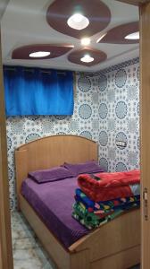 a bedroom with a bed with purple sheets and a ceiling at Dar Bouchikhi in Moulay Yacoub