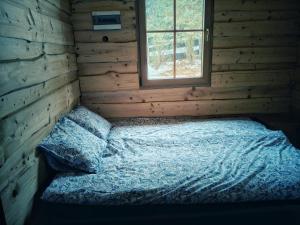 een bed in een blokhut met een raam bij Nowy Gaj in Wilczyn