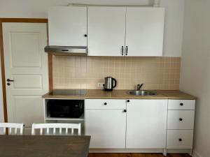 a kitchen with white cabinets and a sink at Spacious one bedroom Ausekļa apartment in Liepāja