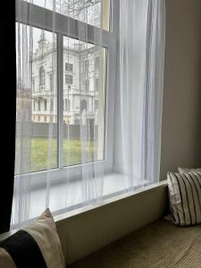 a window with white curtains in a room at Spacious one bedroom Ausekļa apartment in Liepāja