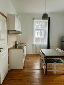 a kitchen and dining room with a table and a window at Spacious one bedroom Ausekļa apartment in Liepāja
