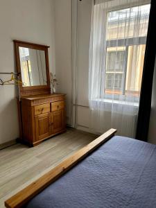 a bedroom with a mirror and a dresser and a window at Spacious one bedroom Ausekļa apartment in Liepāja