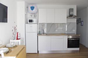 a white kitchen with a sink and a refrigerator at Sonnen & Mar in Antigua