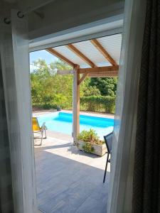 a view of a swimming pool from a house with a patio at Villa Luciole Man'Néa in Sainte-Anne