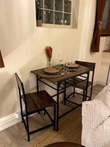 サン・ゴーダンスにあるAppartement Nid Bohème - Romantique et Cosyのダイニングルームテーブル(椅子2脚、ワイングラス付) +2枚の写真