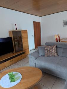 DiemelseeFerienwohnung am Diemelsee in Heringhausen的客厅里有一张沙发和一张桌子。 更多12张照片