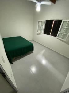 casa de temporada litoral Boraceia Beach - são sebastião في ساو سيباستياو: غرفة بسرير اخضر ونافذة +4 صور