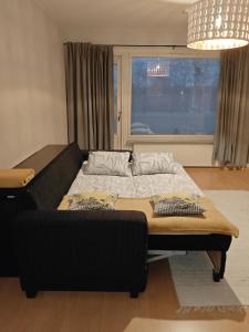 un letto in una stanza con un divano e una finestra di Peaceful and spacious apartment with free parking a Kemi