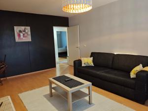 un soggiorno con un divano nero e un tavolo di Peaceful and spacious apartment with free parking a Kemi