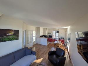 a living room with a blue couch and a kitchen at Couvent Providence in Chartres