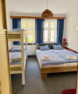 a bedroom with two bunk beds with blue curtains at Chata Amálka in Rokytnice nad Jizerou