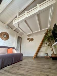 a bedroom with a bed and a wooden floor at Bwa Kanel - Logement moderne avec SPA- Venez profiter d'une parenthèse de bien-être ! in Ducos +9 photos