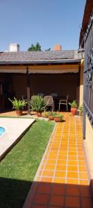 ein Garten mit einem gelben Backsteinweg neben einem Haus in der Unterkunft La Emilia Casa de Vacaciones con Pileta y Quincho in Salta