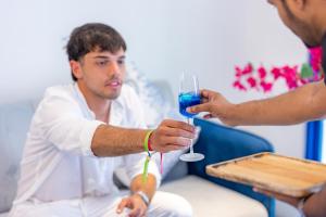 a man is holding a glass of blue wine at Santorini Maafushi Maldives in Maafushi +75 photos