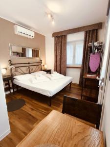 a bedroom with a large white bed and a window at La Bouganville in Arco