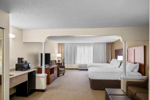 Comfort Suites Grandville - Grand Rapids SW في غراندفيل: غرفة فندق كبيرة بها سرير وأريكة +67 صورة