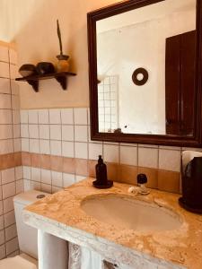 Ateliê Cultural Trancoso في ترانكوسو: حمام مزود بحوض ومِرآة