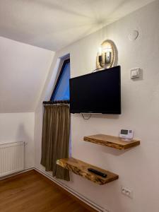 a living room with a flat screen tv on a wall at Pensiunea Pusu in Ranca
