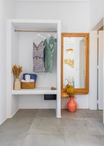 a white room with a mirror and a shelf at Manolis And Filio Home -By The Sea in Pachaina