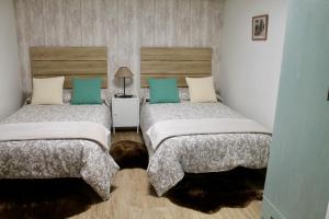 2 letti in una camera con verde e bianco di Casa: El Portalón de Valdivia a Pomar de Valdivia Altre 72 foto