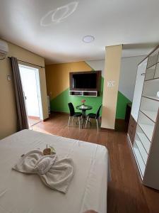 una habitación con una cama y una mesa con sillas en Sumaúma Hotel, en Tefé