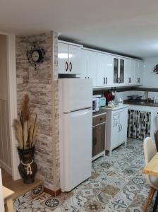 una cucina con mobili bianchi e un frigorifero bianco di Casa: El Portalón de Valdivia a Pomar de Valdivia