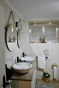 un bagno con due lavandini e due specchi di Casa: El Portalón de Valdivia a Pomar de Valdivia